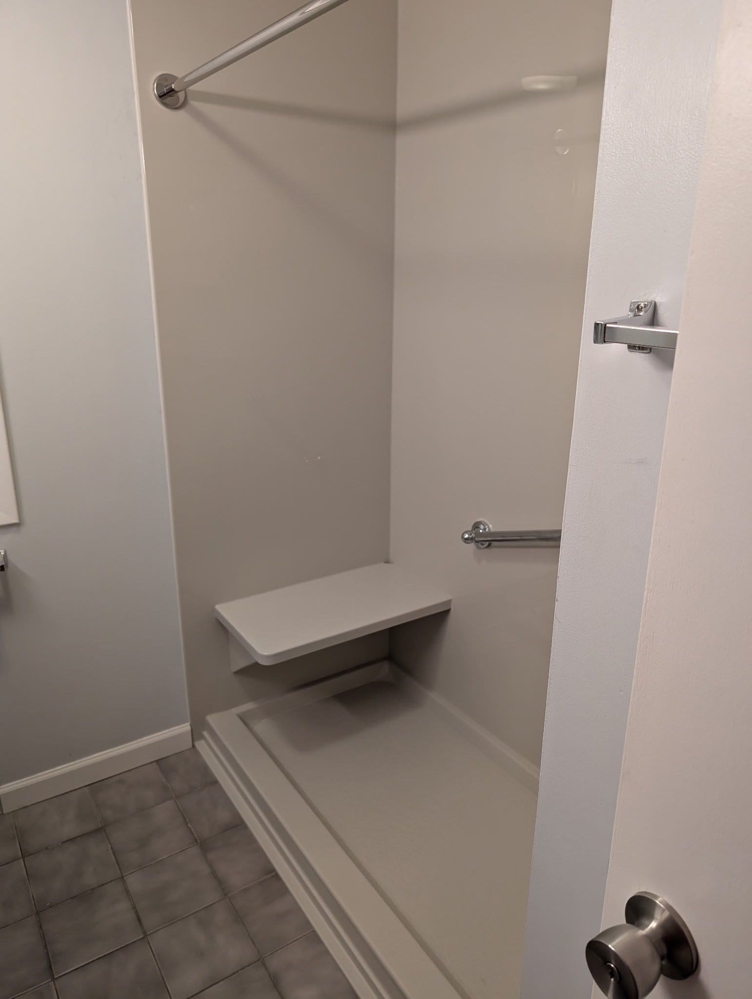 A modern, beautifully tiled walk-in shower with a glass door, which replaced an old bathtub in a Worcester, MA, home.